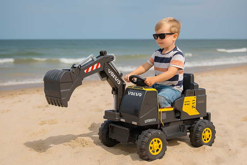 Chłopiec na koparce Volvo na plaży